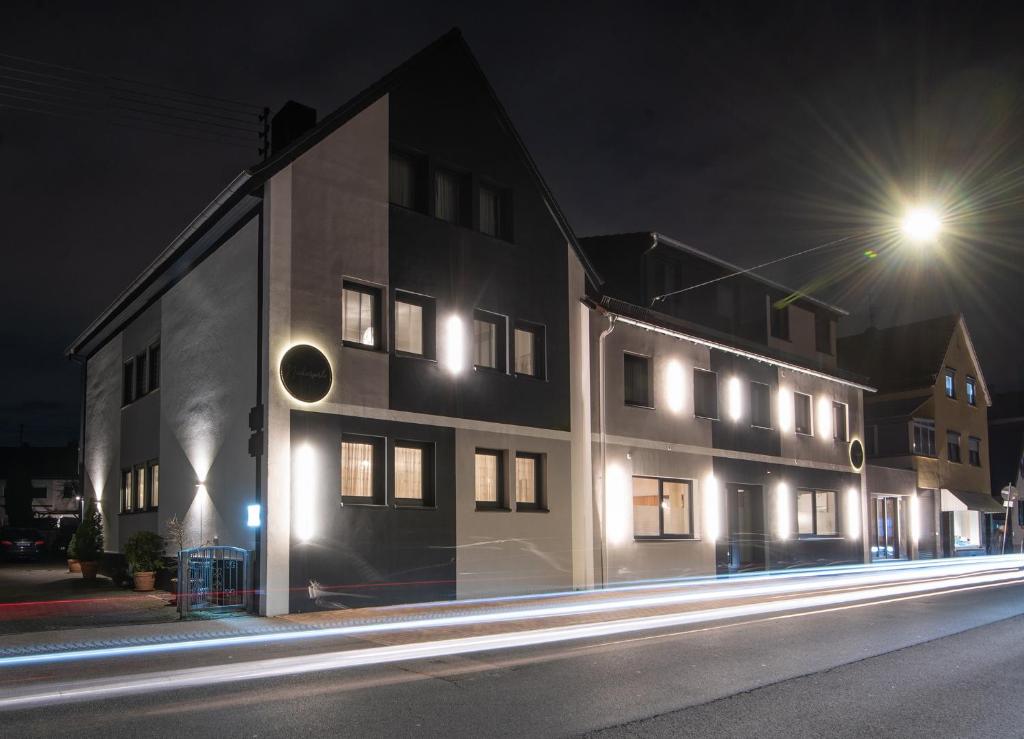 un bâtiment avec des lumières sur son côté la nuit dans l'établissement Neckarperle, à Edingen-Neckarhausen