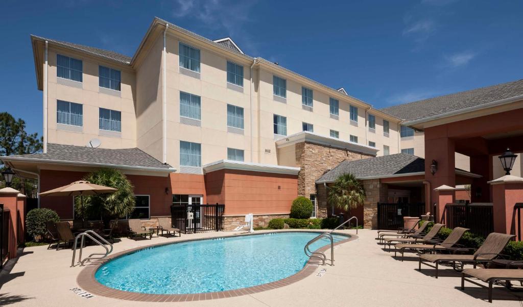 スタッフォードにあるHomewood Suites by Hilton Houston Stafford Sugar Landの建物の前にスイミングプールがあるホテル