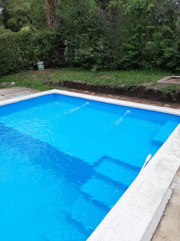 une grande piscine bleue dans une cour dans l'établissement Sierras Chicas La Granja, à Córdoba