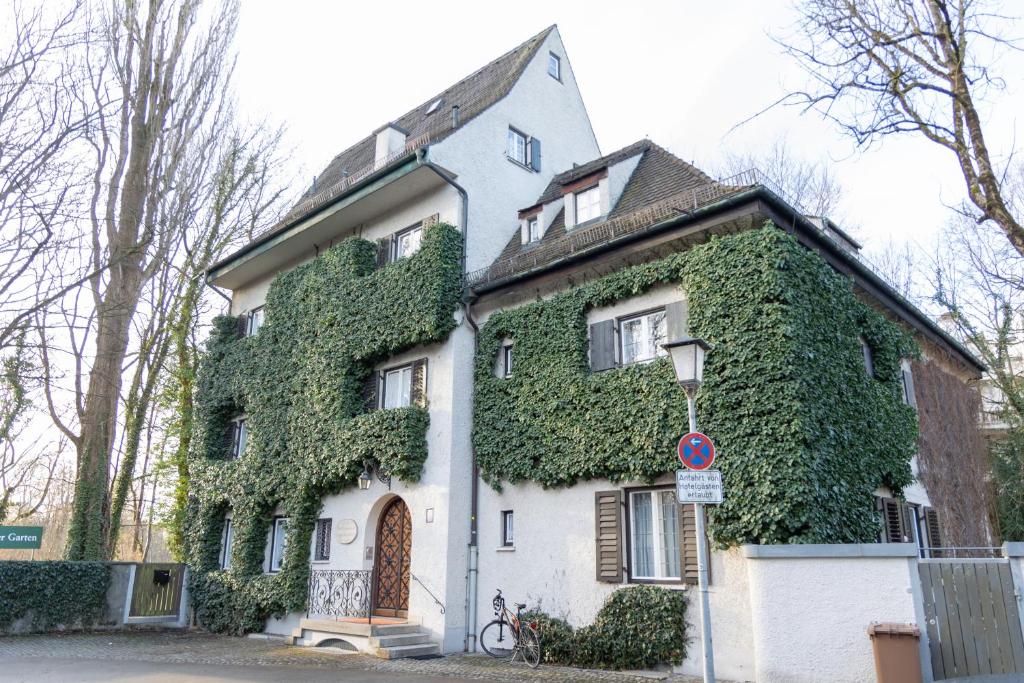 Gästehaus Englischer Garten في ميونخ: البيت الأبيض مع اللبي الأخضر عليه