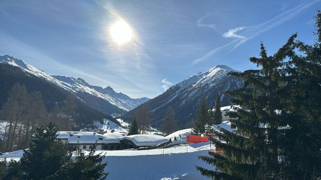 een met sneeuw bedekte berg met de zon in de lucht bij Chalet Studio - Top Ausstattung - beste Lage Davos in Davos