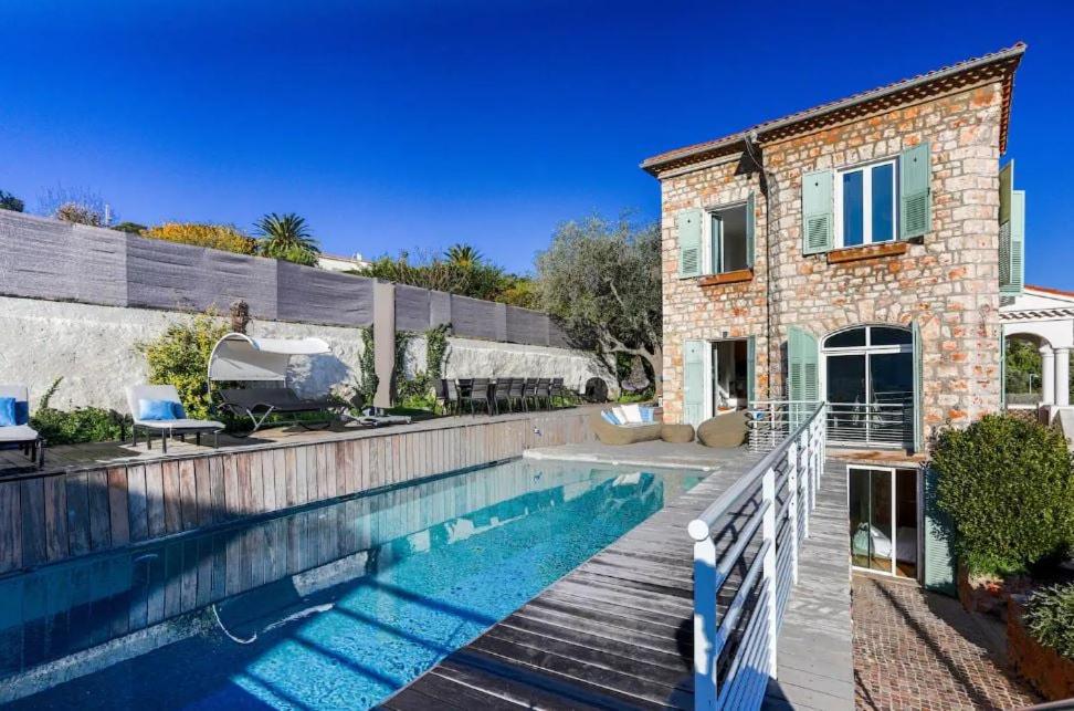 a house with a swimming pool in front of a house at Villa Élégante Nice avec Vue Mer in Nice