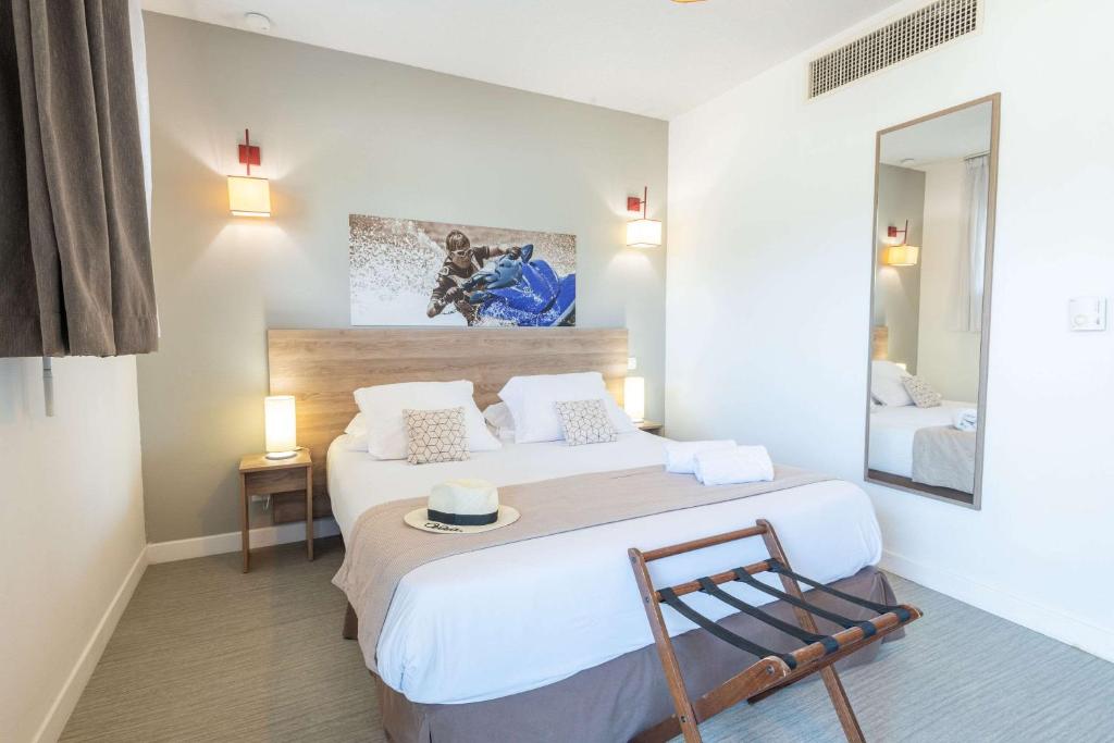 Rúm í herbergi á Comfort Aparthotel Cannes Mandelieu