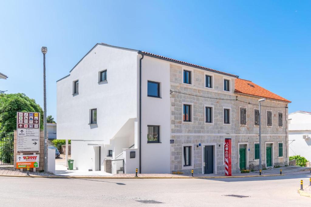 um edifício branco ao lado de uma rua em Stone house em Baška Voda