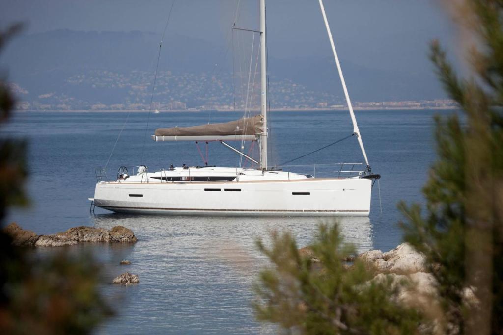 um barco à vela branco sentado na água em Sleep aboard a modern sailboat in Oeiras em Oeiras