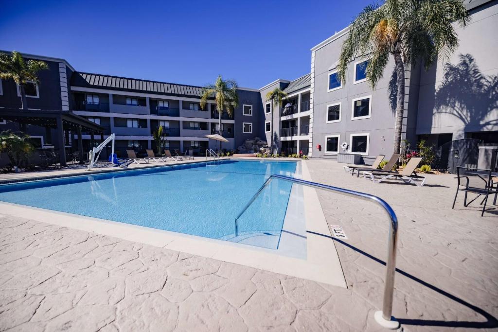 uma grande piscina num pátio com um edifício em La Quinta Inn by Wyndham Tampa Near Busch Gardens em Tampa