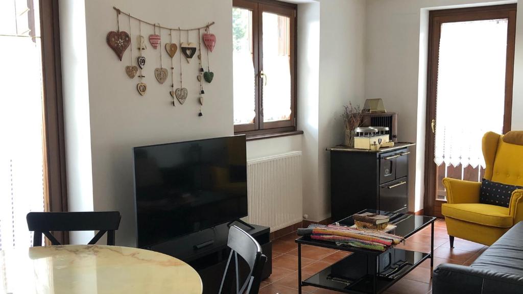 a living room with a flat screen tv and a table at Lioda Roccia in Masariè