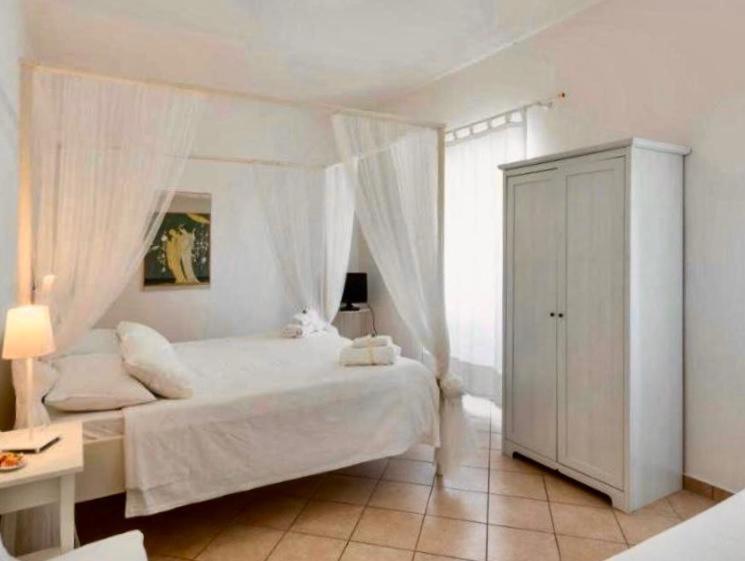 een slaapkamer met een wit bed en een witte kast bij La locanda di Andrea il pescatore in Borgo Montenero