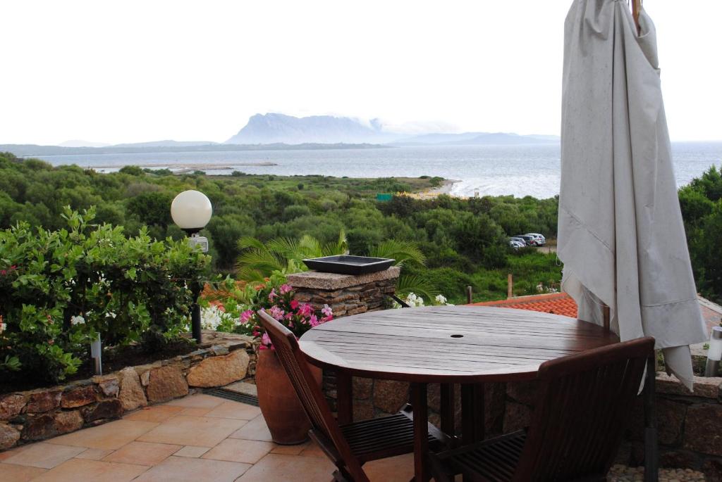 una mesa y sillas en un balcón con vistas al océano en Villa Minda Lodge & View, en San Teodoro