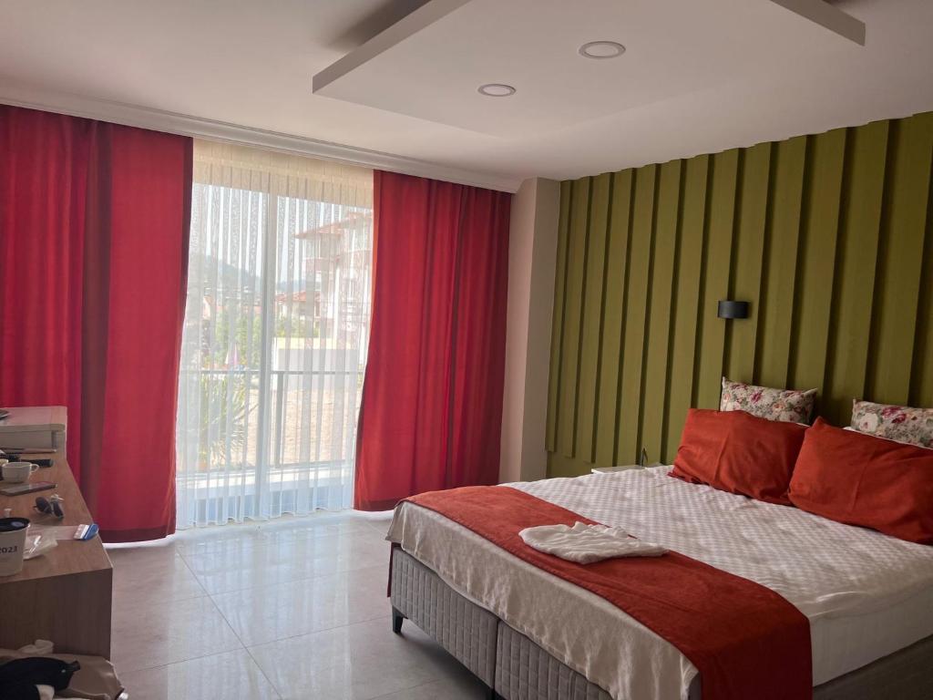 een slaapkamer met een groot bed met rode en groene muren bij Hayat Apart Hotel in Oludeniz