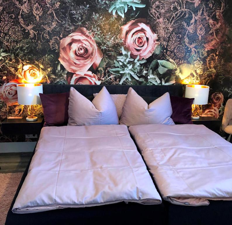 a bed in a room with roses on the wall at Ferienwohnung Auszeit in Chemnitz