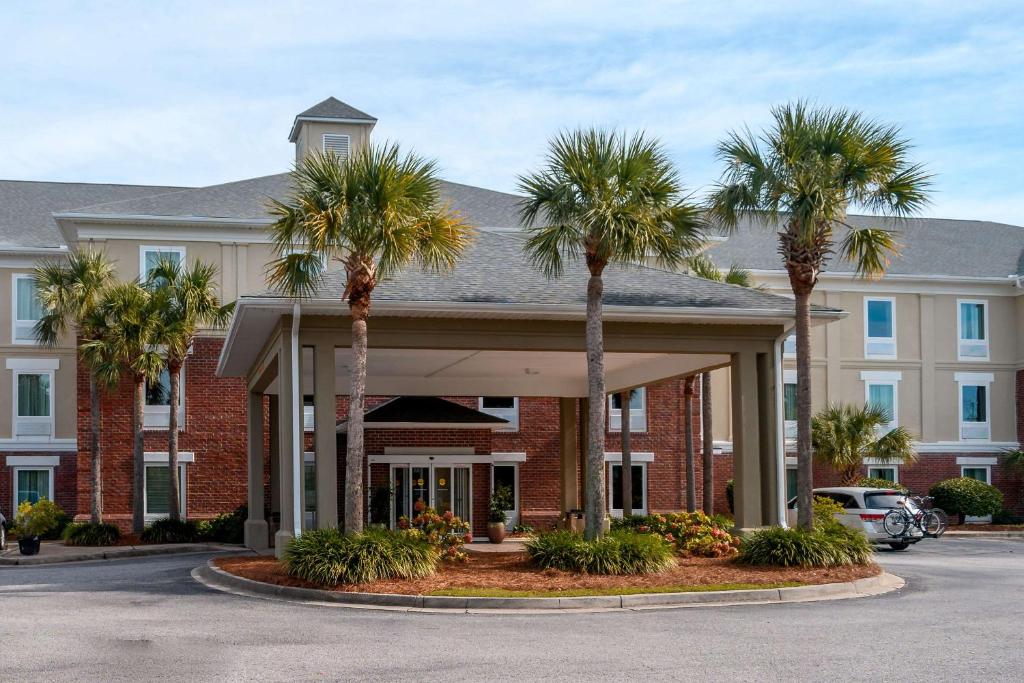 un hotel con palmeras frente a un edificio en Comfort Inn & Suites Patriots Point, en Charleston