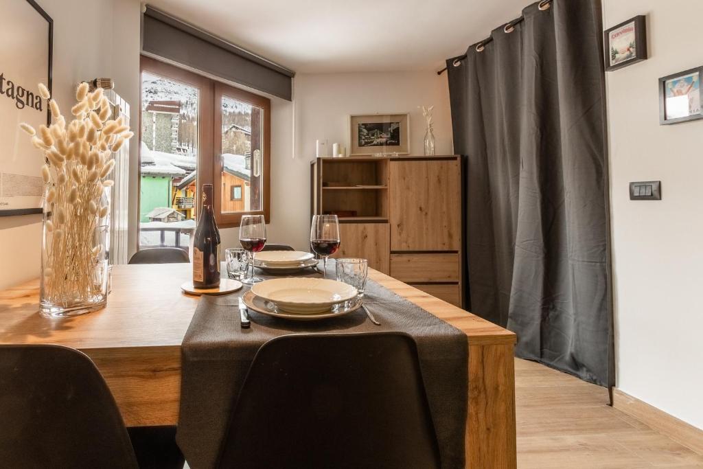 a dining room with a wooden table with wine glasses at HelloChalet - Friends Ski House in Breuil-Cervinia