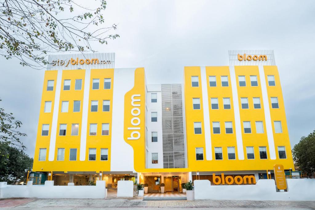 Bloom Hotel - Medicity Gurugram, Near Medanta Hospital في جورجاون: مبنيان مصفران عليهما علامة سلوان