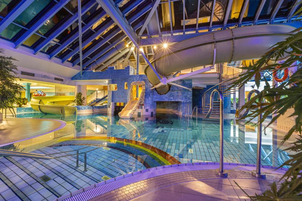 una piscina coperta con scivolo in un edificio di IFA Rügen Hotel & Ferienpark a Binz