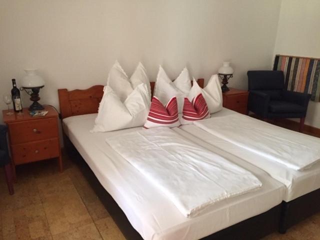 a bedroom with a large bed with red and white pillows at Cicáskacus Vendégház in Matrafured