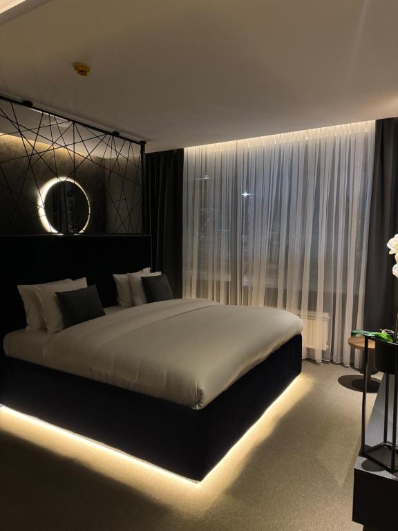 a bedroom with a large bed with a light on it at Olivia Rooms in Belgrade