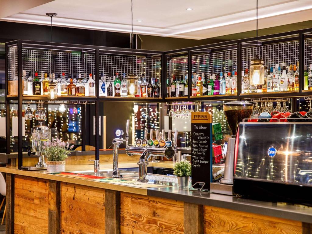 un bar con un mostrador con mucho alcohol en ibis Bristol Centre en Bristol