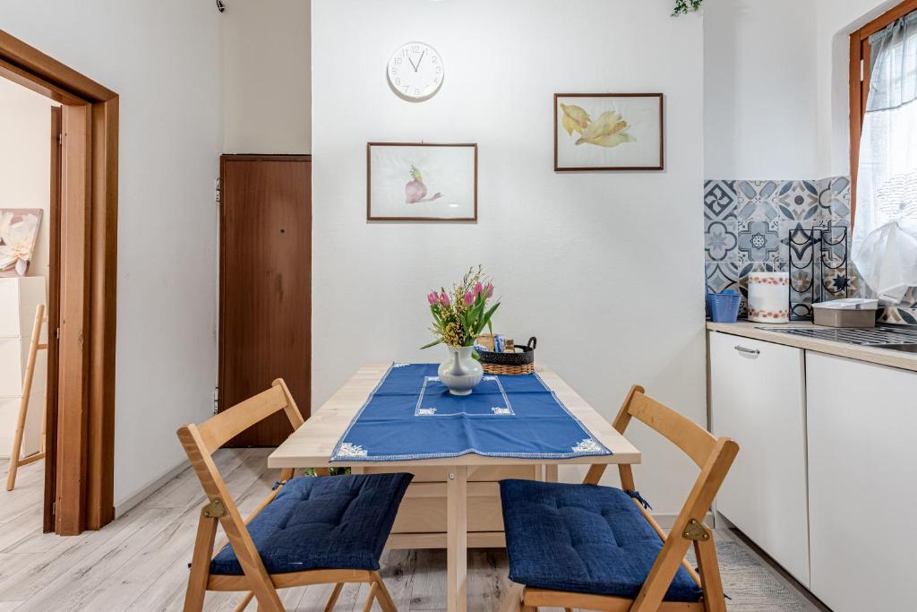 a kitchen with a wooden table with chairs and a table at Nel cuore del rione del Drago in Pistoia