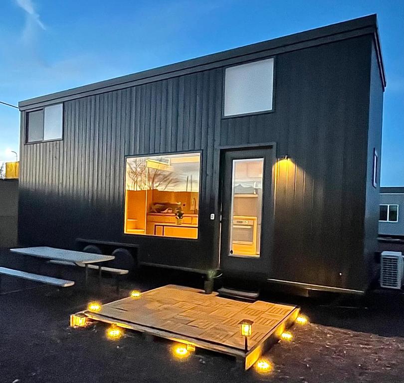 una casita negra con luces en un estacionamiento en Tiny home near Grand Canyon sleeps 5, epic views!, en Flagstaff