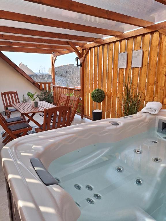 a jacuzzi tub on a deck with a table at Várfal apartman II in Eger