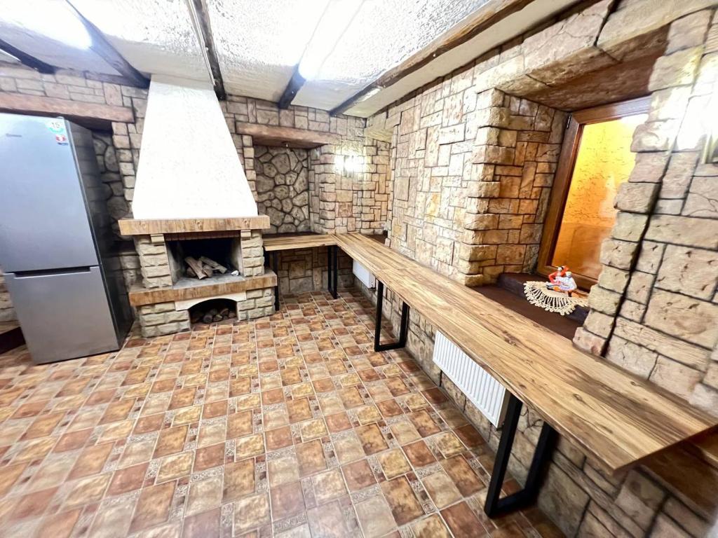 a large kitchen with a stone fireplace and a refrigerator at Like Hostel in Chişinău