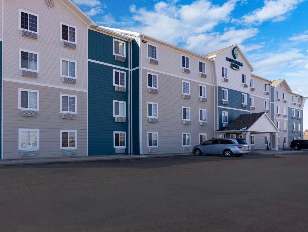 un gran edificio con un coche aparcado delante de él en WoodSpring Suites Champaign near University, en Champaign