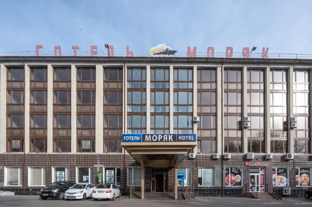 um grande edifício com uma placa para um hotel em готель Моряк em Chornomorsk