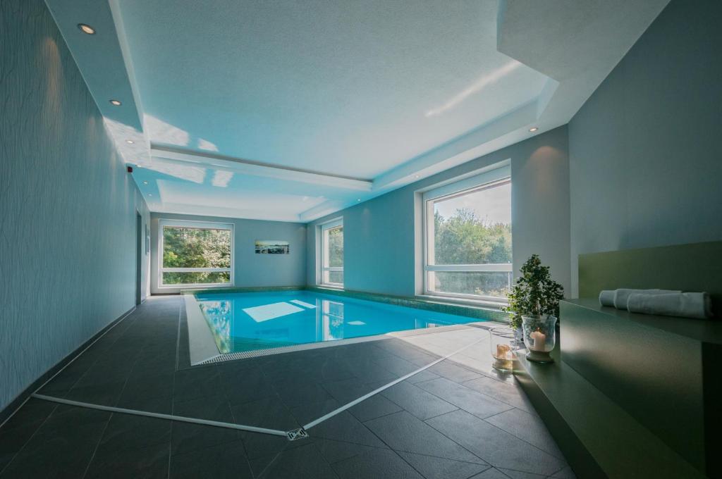 Cette grande chambre dispose d'une piscine aux murs bleus. dans l'établissement Hotel Fortuna Reutlingen-Tübingen, à Reutlingen