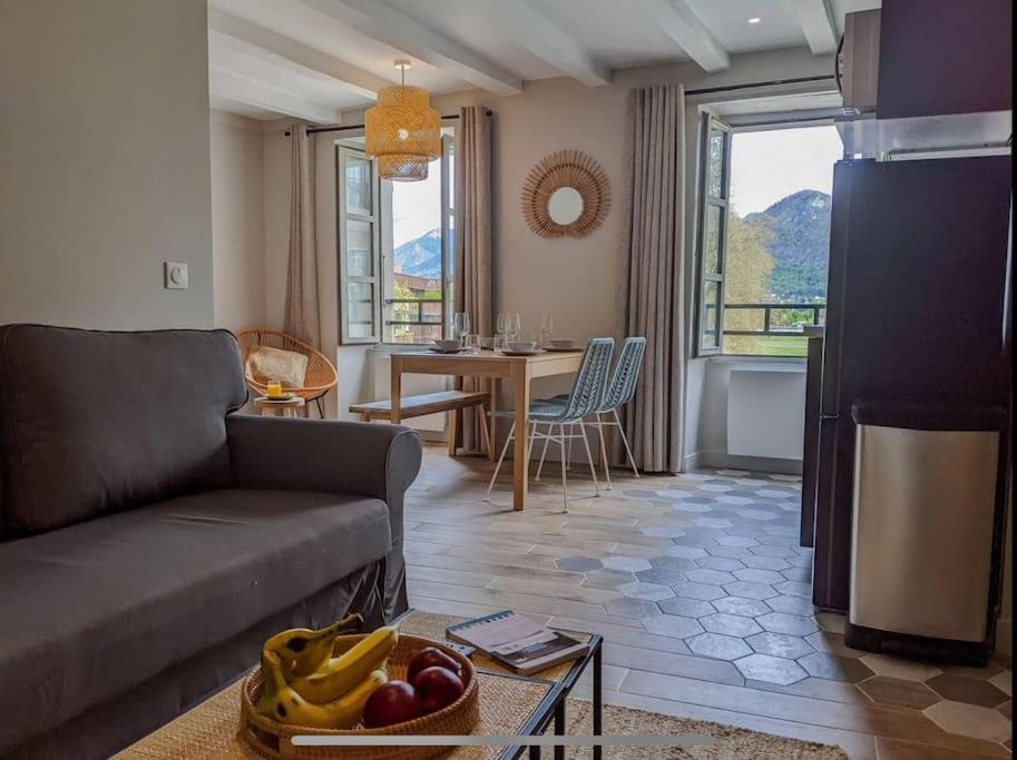 een woonkamer met een bank en een tafel bij La Perle du Lac 3* - VUE LAC in Annecy