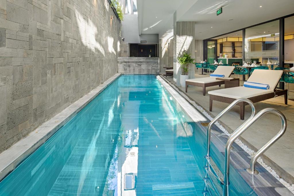 una piscina de agua azul en un edificio en Satya Da Nang Hotel Han Market, en Da Nang