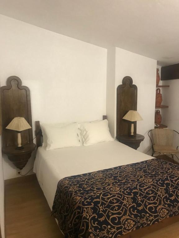 a bedroom with a large bed with two lamps at Hotel Portofoz in Porto