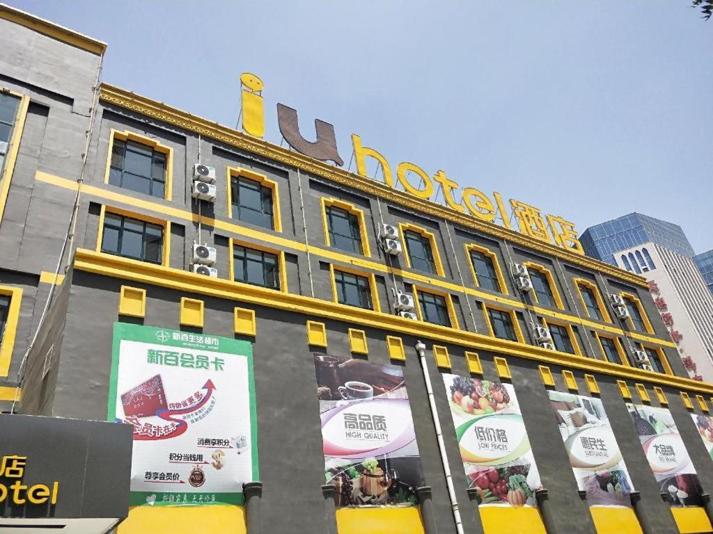 银川IU Hotels·Yinchuan Railway Station的建筑的一侧有酒店标志