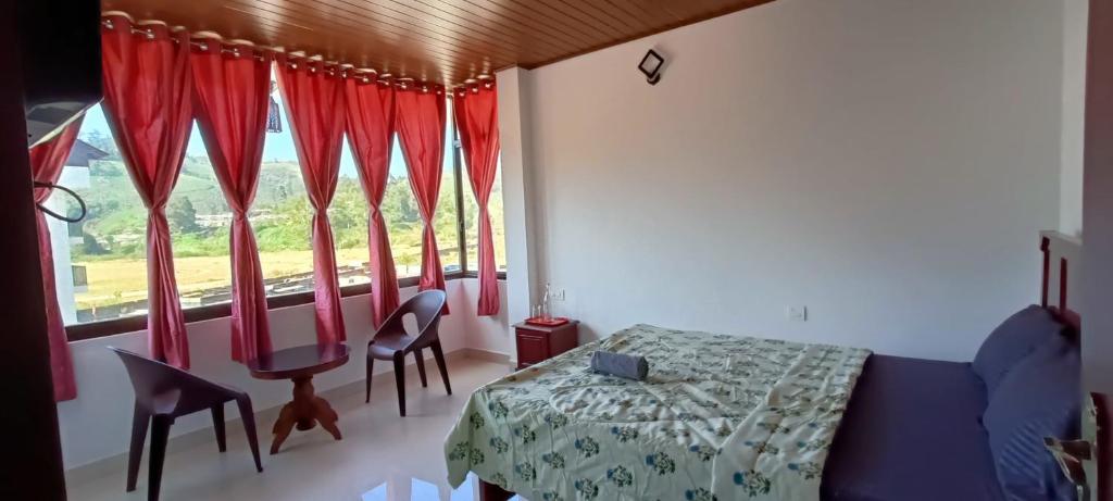 1 dormitorio con 1 cama y una ventana con cortinas rojas en Pranav 4 Seasons, en Munnar