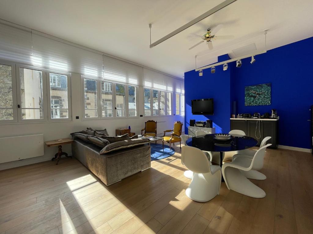 een woonkamer met een bank en een tafel en stoelen bij Le Loft du Homard Bleu à Saint-Malo Intra-Muros in Saint-Malo