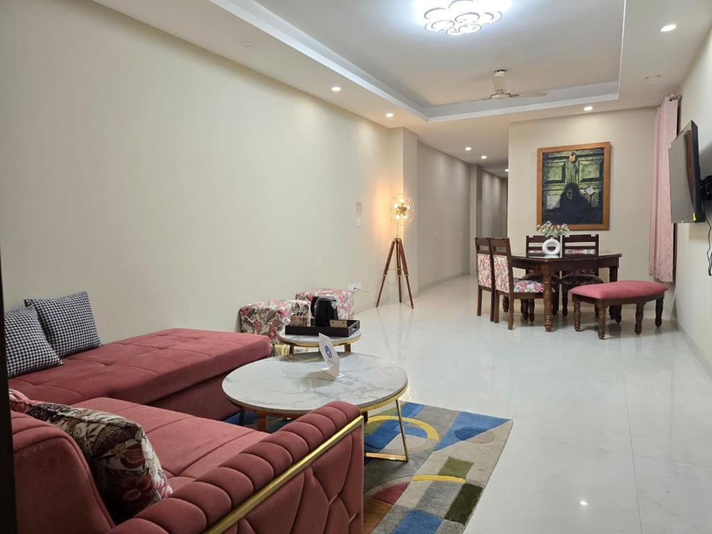 - un salon avec des canapés rouges et une table dans l'établissement Homlee-Saket Anupam Stylish 3BHK in South Delhi, à New Delhi