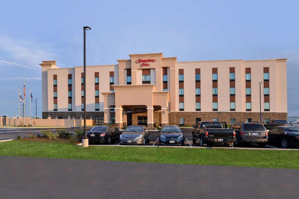 un gran edificio con coches estacionados en un estacionamiento en Hampton Inn Broussard-Lafayette, en Broussard