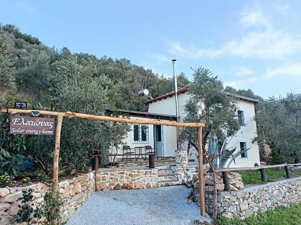 a small white house with a sign in front of it at Ελαιώνας - Solar Energy House in Chorefto