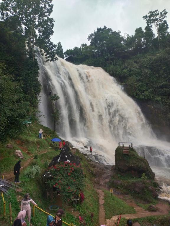 una cascata con persone che ci stanno di fronte di Wildan Homestay a Mangun