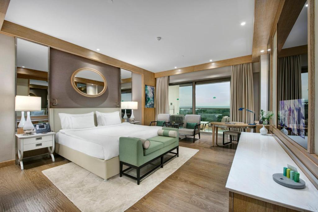 - une chambre avec un grand lit et un salon dans l'établissement Regnum Carya, à Belek