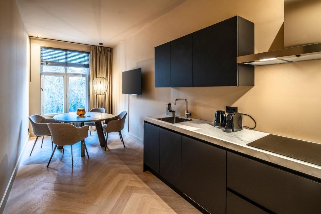 une cuisine avec un évier et une table avec des chaises dans l'établissement Breda City Apartments, à Breda