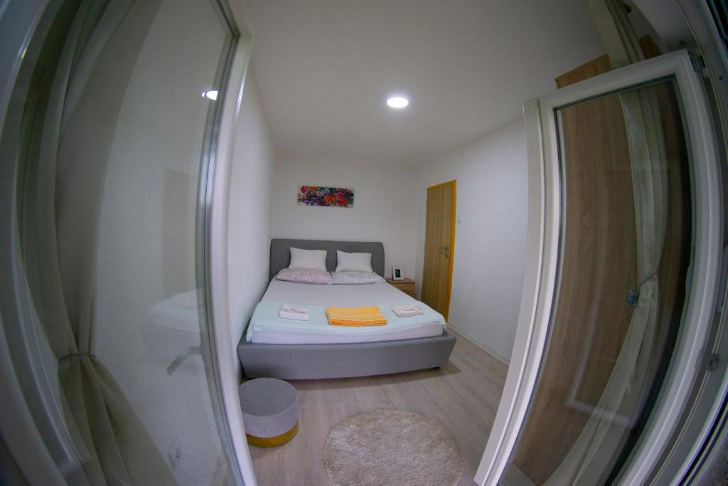 een kleine slaapkamer met een bed en een douche bij UKROPINA APARTMENTS in Trebinje