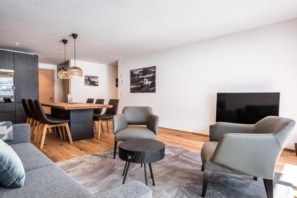 salon z kanapą, krzesłami i stołem w obiekcie Apartment Walt 3.5 - GRIWA RENT AG w mieście Grindelwald