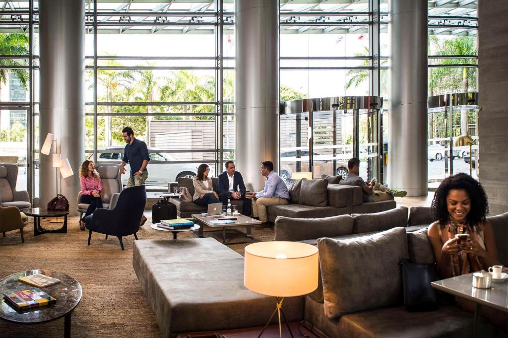 eine Gruppe von Personen, die in einem Wohnzimmer sitzen in der Unterkunft Grand Hyatt São Paulo in São Paulo