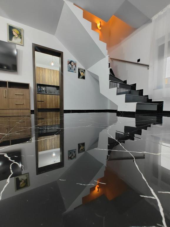 a staircase in a room with black and white floors at Black&White House in Ocna-Mureşului