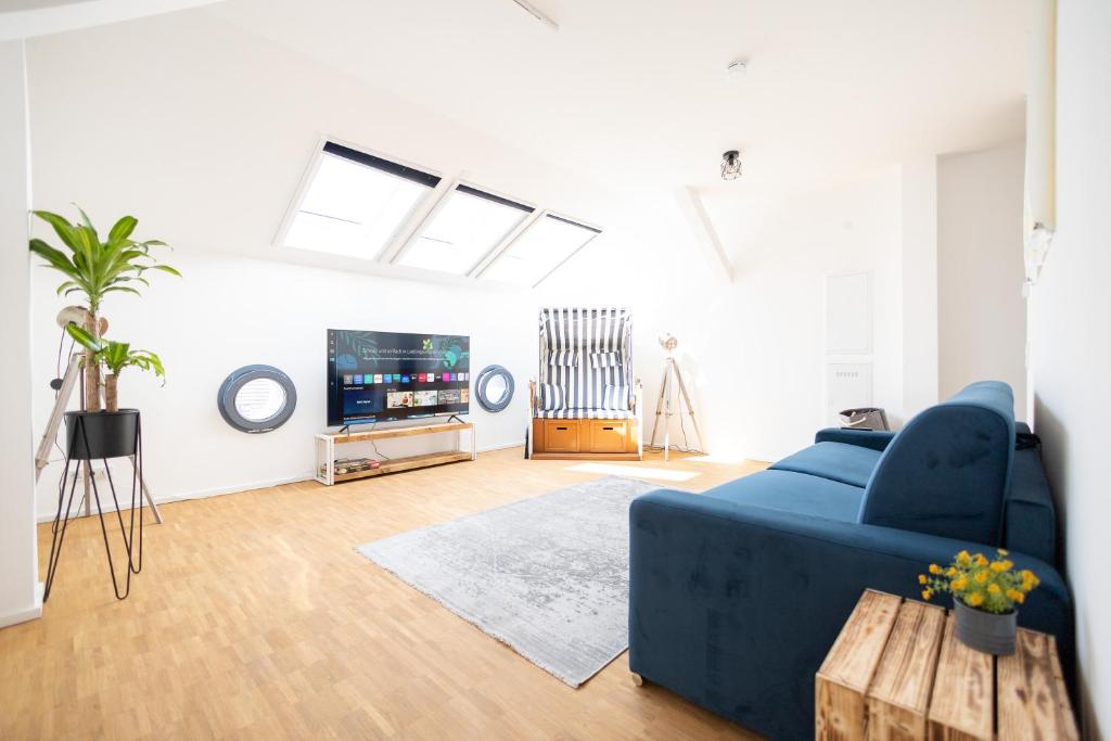 een woonkamer met een blauwe bank en een tv bij Ko-Living - Captain's Suite - Altstadt - mit Küche, Smart TV & Balkon - 6P in Halle an der Saale