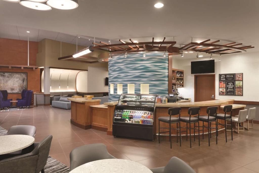 een restaurant met een bar met stoelen en een keuken bij Hyatt Place Portland Airport/Cascade Station in Portland