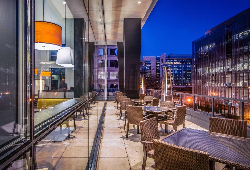 un restaurant avec des tables et des chaises sur un balcon dans l'établissement Hyatt Place Washington D.C./National Mall, à Washington