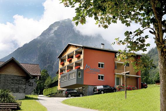 un gran edificio con una montaña en el fondo en Hotel Garni Madrisa, en Brand