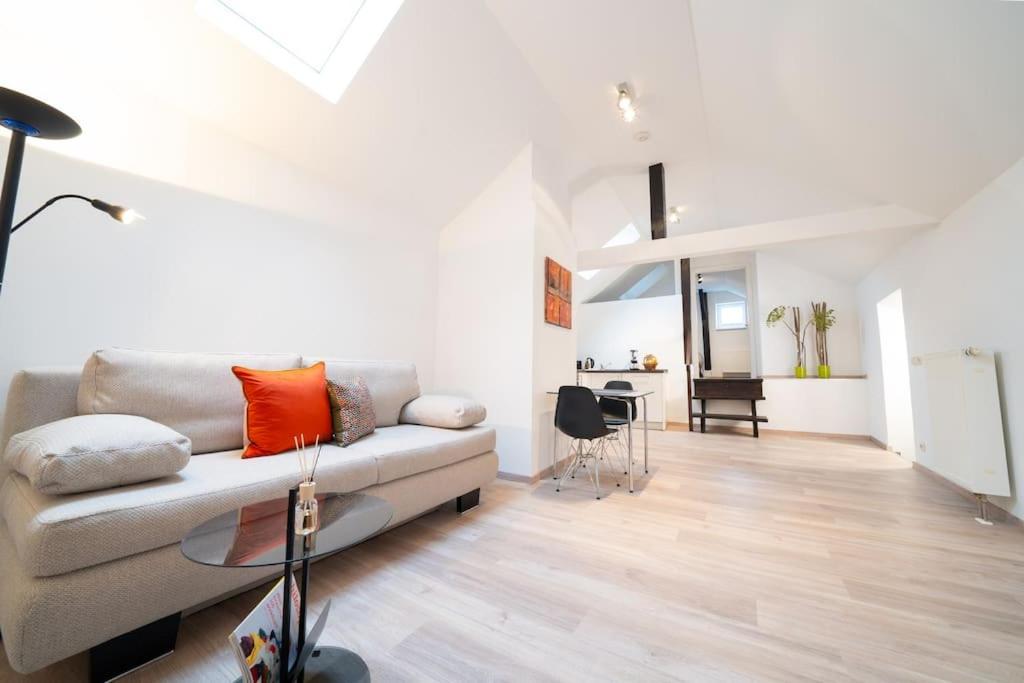 un soggiorno con divano e tavolo di NEW modernes Loft im Zentrum von Deggendorf a Deggendorf